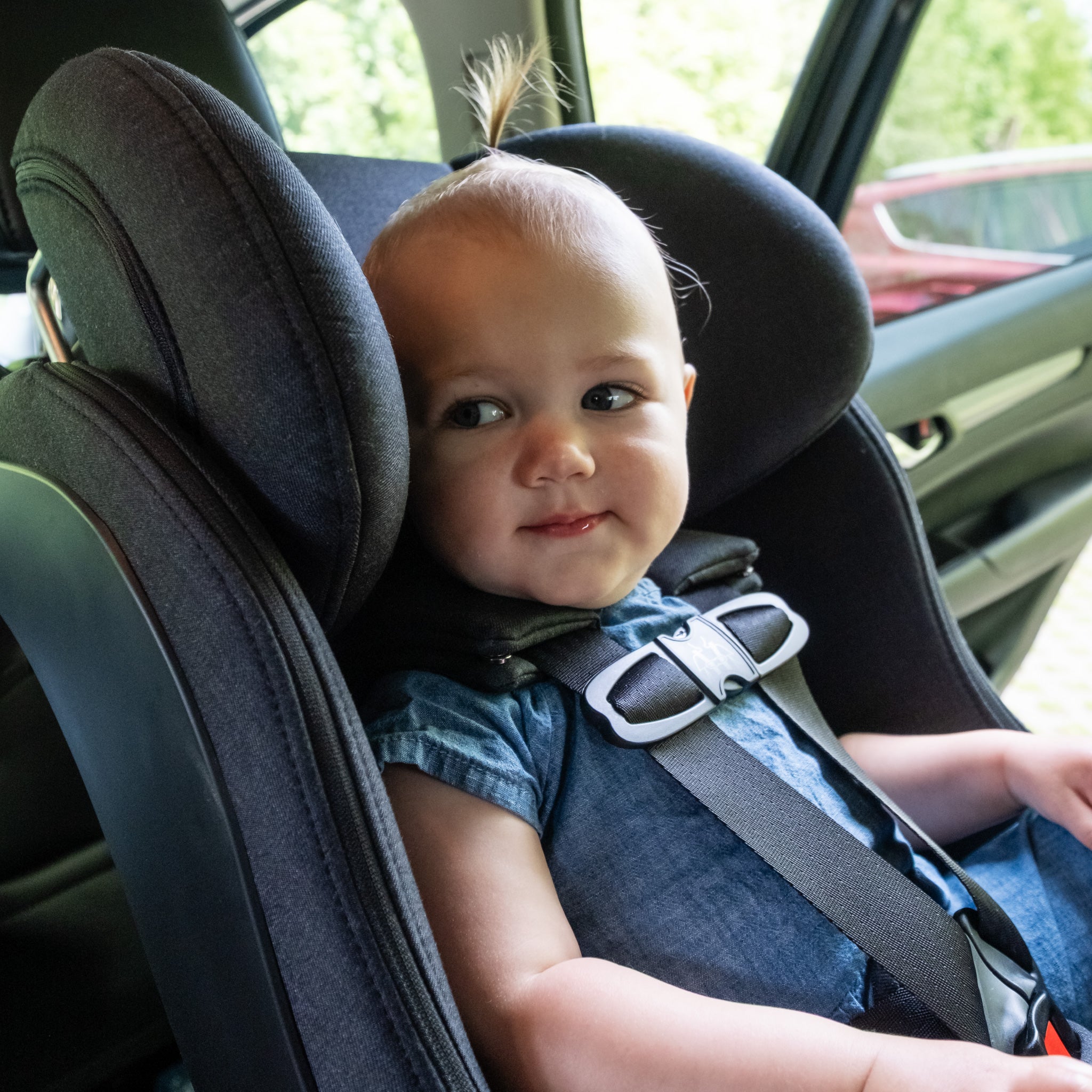 Child in a Foonf car seat inside a vehicle with a blurred background all-groups