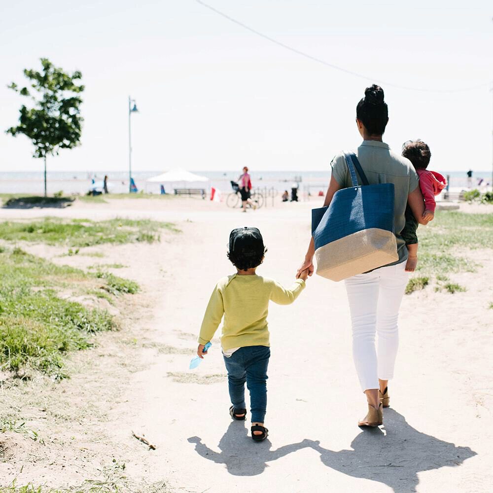 Mom walking with her child to the beach