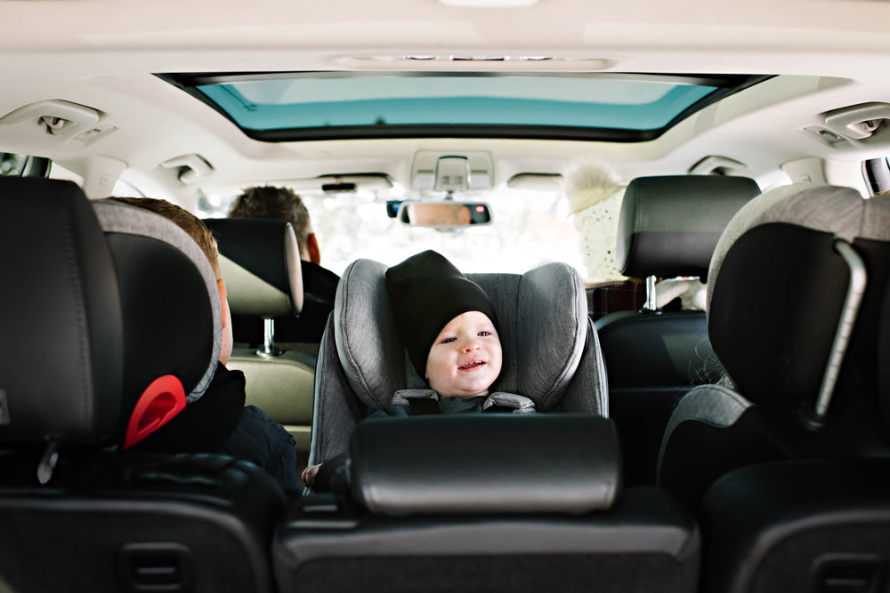 Child riding in their Clek convertible car seat in rear-facing mode