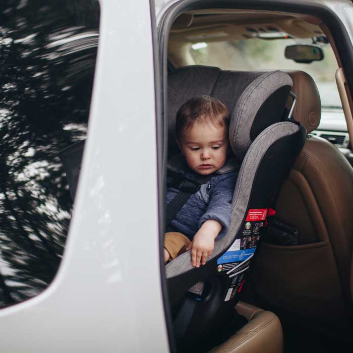Child sitting in a Clek Fllo convertible car seat installed rear-facing.