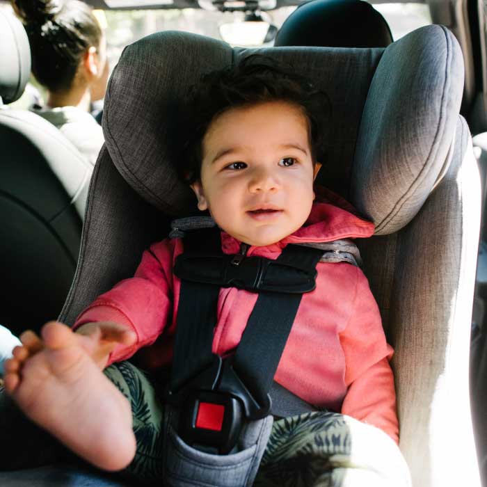 Child buckled into a Clek Foonf Convertible Car Seat in rear-facing mode
